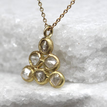Load image into Gallery viewer, Gold necklace with a pendant featuring clear gemstones on a textured white background