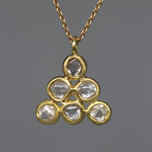 Load image into Gallery viewer, Gold necklace with a triangular pendant featuring clear gemstones on a dark gray background