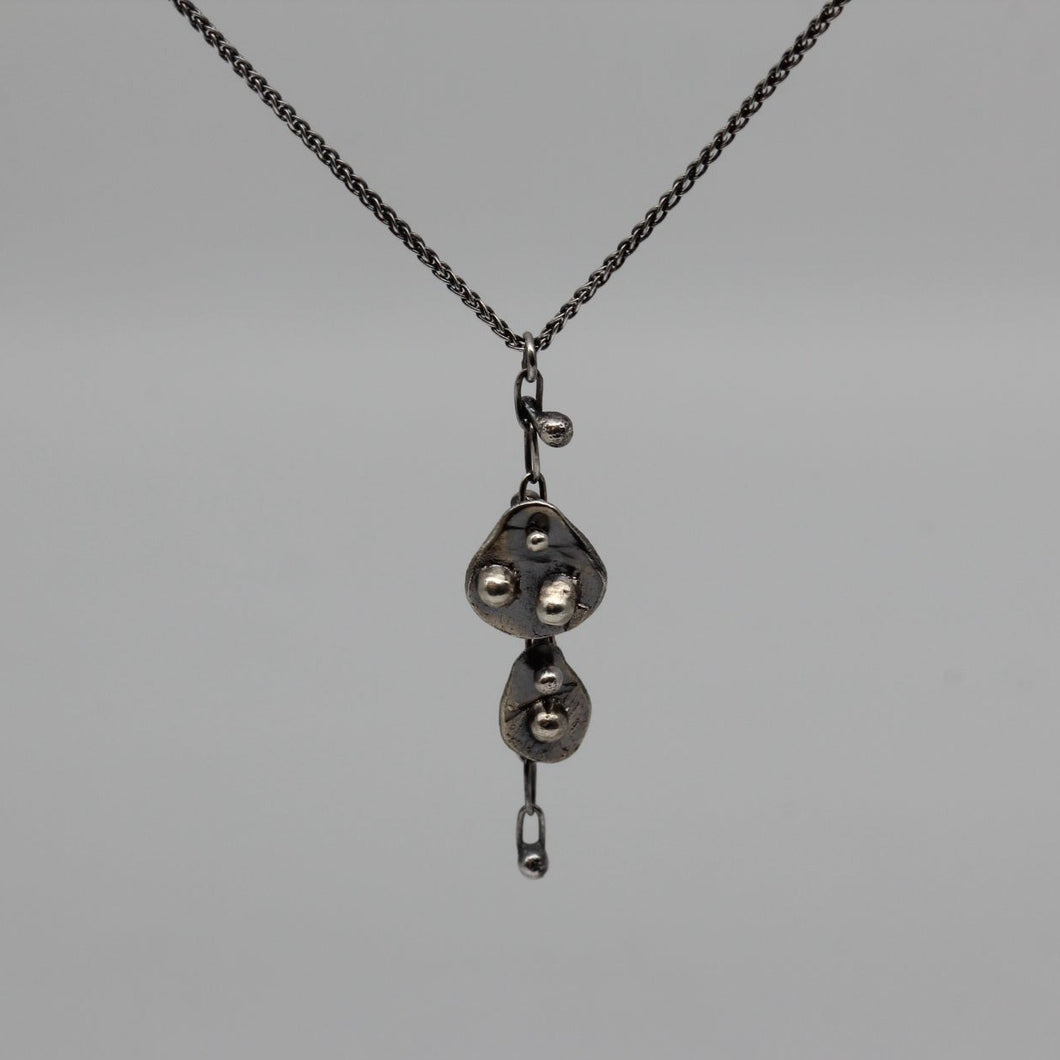Double Oddity drop pendant necklace in blackened silver.