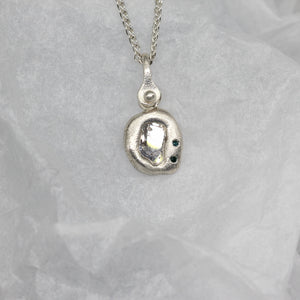 Diamond slice pendant necklace in sterling silver with blue diamonds by Tamara Gomez