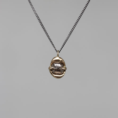 Sculptural rough diamond pendant in brushed gold on a fine blackened silver chain, handcrafted in London by Tamara Gomez.