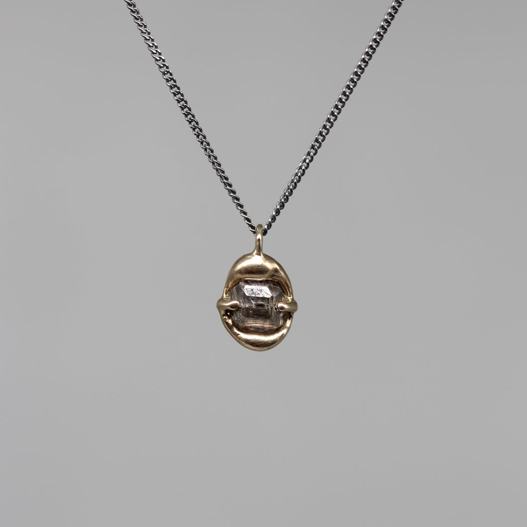 Sculptural rough diamond pendant in brushed gold on a fine blackened silver chain, handcrafted in London by Tamara Gomez.